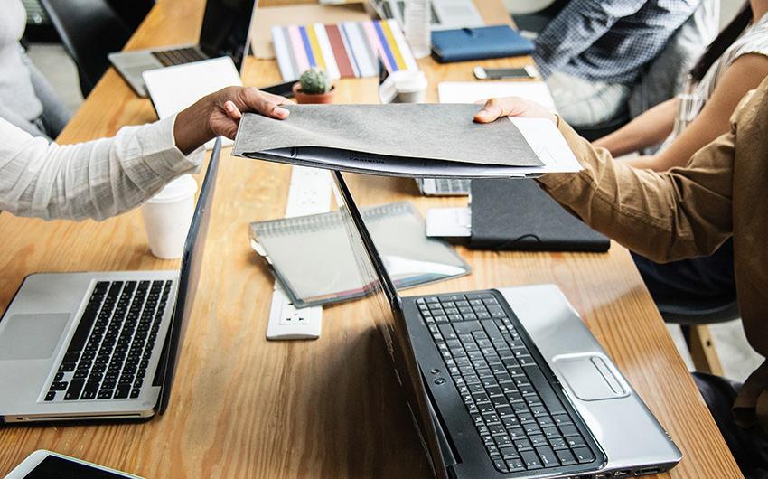 People passing papers across a desk